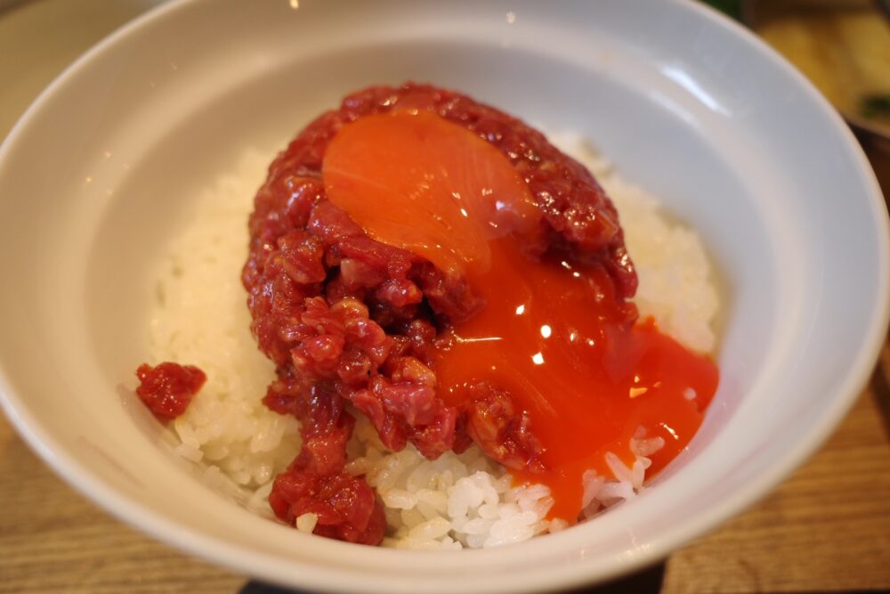 黄身を割った究極のユッケ丼